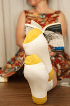 A Person Wearing Out Of Print Bookworm Crew Socks, in cream