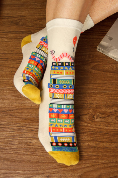 A Person Wearing Out Of Print Bookworm Crew Socks, in cream