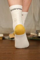A Person Wearing Out Of Print Bookworm Crew Socks, in cream