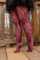 A person wearing wine-colored peacock feather net tights
