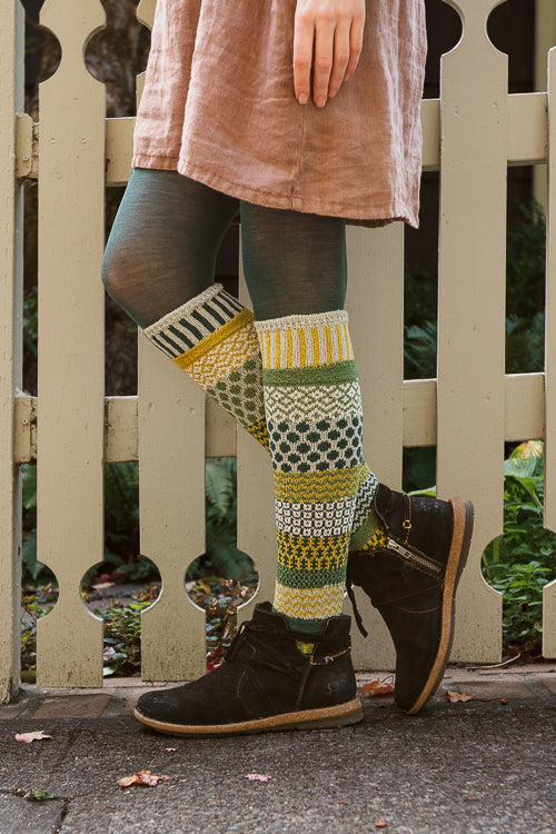 A person wearing fiddlehead knee high socks in various greens