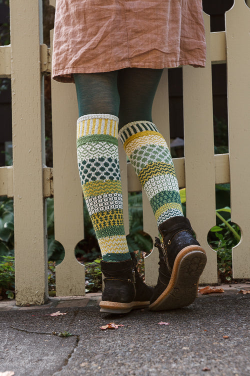 A person wearing fiddlehead knee high socks in various greens