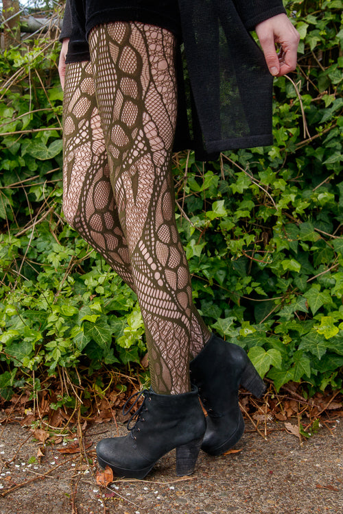 A person wearing celsius net tights in olive color