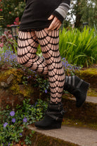 A person wearing mauve black net tights