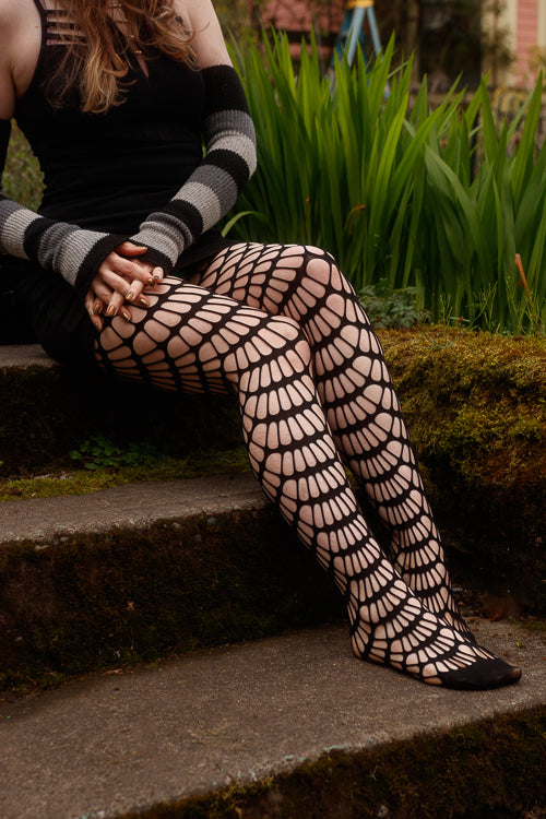 A person wearing mauve black net tights