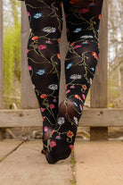 A person wearing Platino floral tights with colorful flowers
