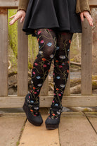 A person wearing Platino floral tights with colorful flowers