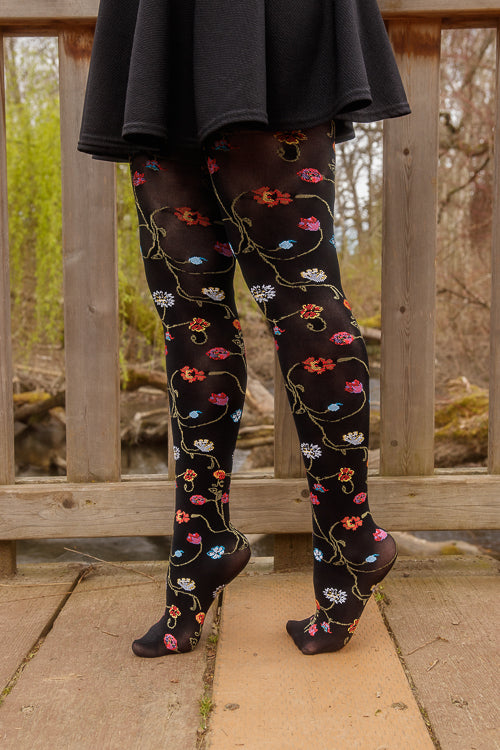 A person wearing Platino floral tights with colorful flowers